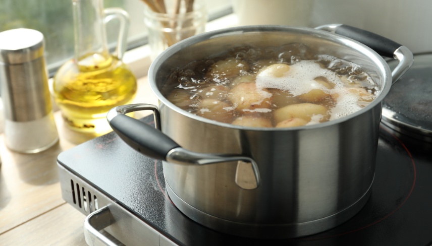 Boiling potatoes in pot on stove in kitchen