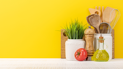 Verschiedene Küchenutensilien und Geschirr auf einem gelben Hintergrund